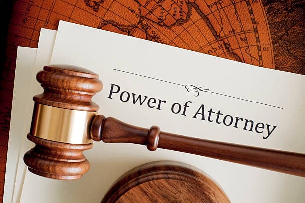Wooden judge's gavel resting on a Power of Attorney legal document representing estate planning and legal authority.